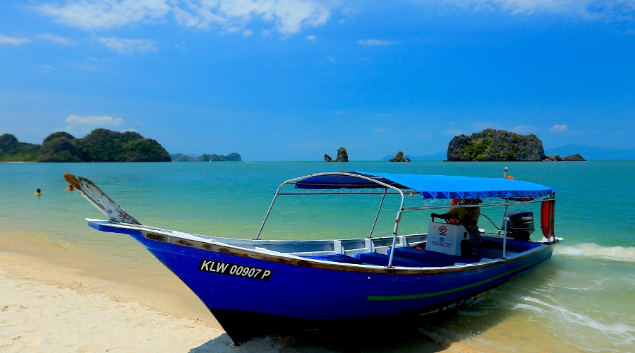 A boat on the scenic freshwater lake on Dayang Bunting Island surrounded by limestone hills and forest.