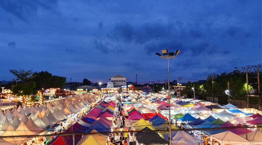Crowded Langkawi night market with food stalls, local dishes, and colorful lights.