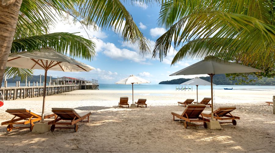 A relaxing scene at Pantai Cenang beach during a sunny day in Langkawi, Malaysia.