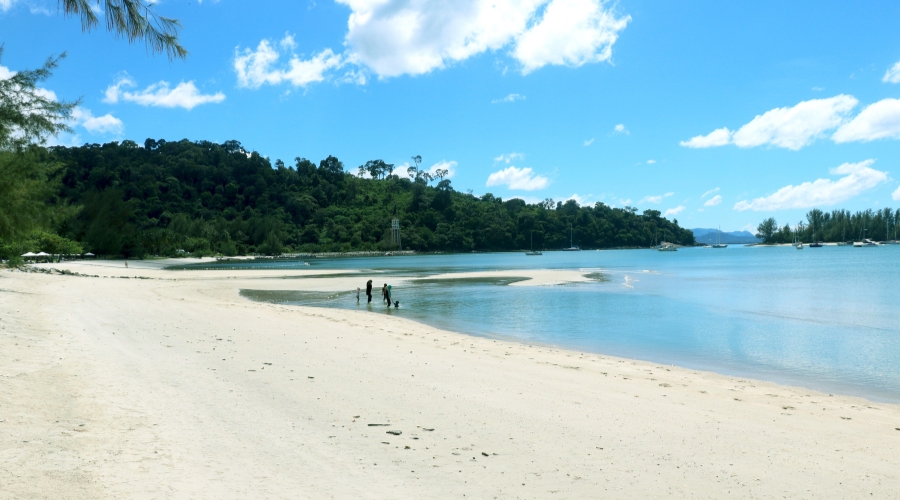 Serene shoreline of Tanjung Rhu Beach in Langkawi with turquoise waters and white sand.
