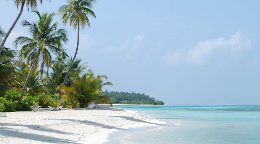 Secluded Pasir Tengkorak Beach in Langkawi with soft white sand and surrounding rainforest.
